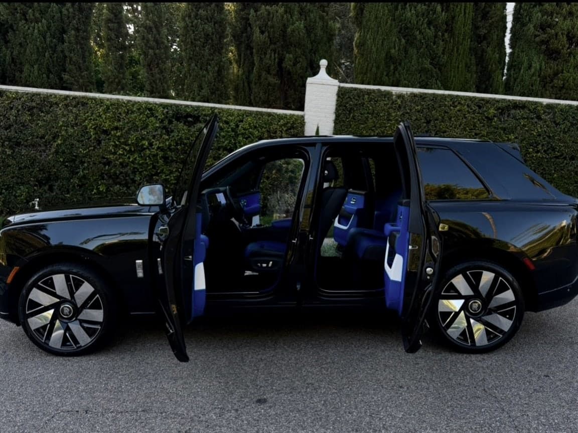 Black Rolls-Royce Cullinan with both coach doors open to a blue-and-white leather interior
